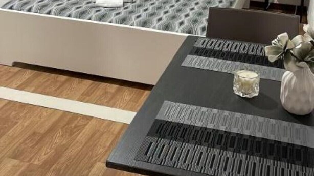Une chambre à coucher bien rangée, avec un lit, des tables de chevet, une table et une chaise.