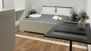Une chambre à coucher moderne avec un lit, une table de chevet et un luminaire suspendu.