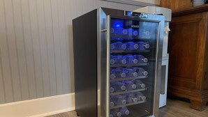 A stainless steel water dispenser with multiple shelves, placed against a wall with vertical paneling. - Room 2 - The Inn at Dirickson Creek (Frankford)