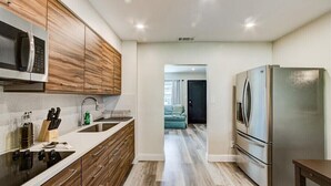 A modern kitchen with wooden cabinets, stainless steel appliances, and a central island with a sink.