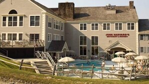 A two-story building with a swimming pool, outdoor seating, and a sign for 'John Harvard's Restaurant & Brewery'. - 1st FL Mtn View Woodland Suite on Jiminy Sleeps 4 Ski On/Off, Fully Redone Count (Hancock)