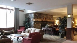A spacious living area with a stone fireplace, comfortable seating, and a dining area with a table and chairs. - 1st FL Mtn View Woodland Suite on Jiminy Sleeps 4 Ski On/Off, Fully Redone Count (Hancock)