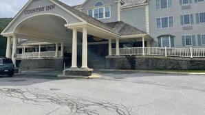 Un edificio de dos pisos con un porche cubierto identificado con el rótulo "Country Inn".