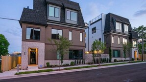 A modern two-story residential building with a brick facade, large windows, and a flat roof. - Close to it all*Rooftop*Photo Walls*BBQ on Roof (Nashville,)