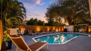 Une piscine avec des chaises longues et une clôture en bois.