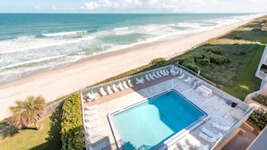 A rooftop pool with lounge chairs and a view of the beach and ocean. - Oceanfront 2BR Condo 6th Floor Corner Unit Indian Harbour Beach, 601 (Indian Harbour Beach)