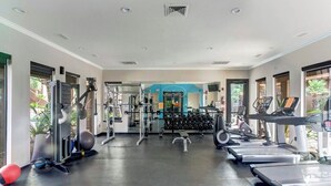 Un gimnasio con cintas de correr, mancuernas y equipo de ejercicio.