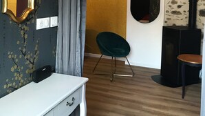 Ein Zimmer mit einem weißen Schreibtisch, einem grünen Stuhl, einem schwarzen Heizkörper und einer Wand mit goldener Struktur.