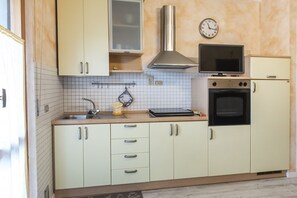Une cuisine équipée d’un évier, d’une cuisinière, d’un four à micro-ondes et de placards.