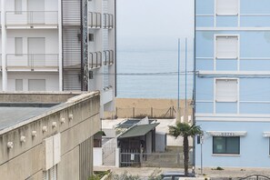 Un hôtel doté d’un balcon, offrant une vue sur la plage et agrémenté d’un palmier.
