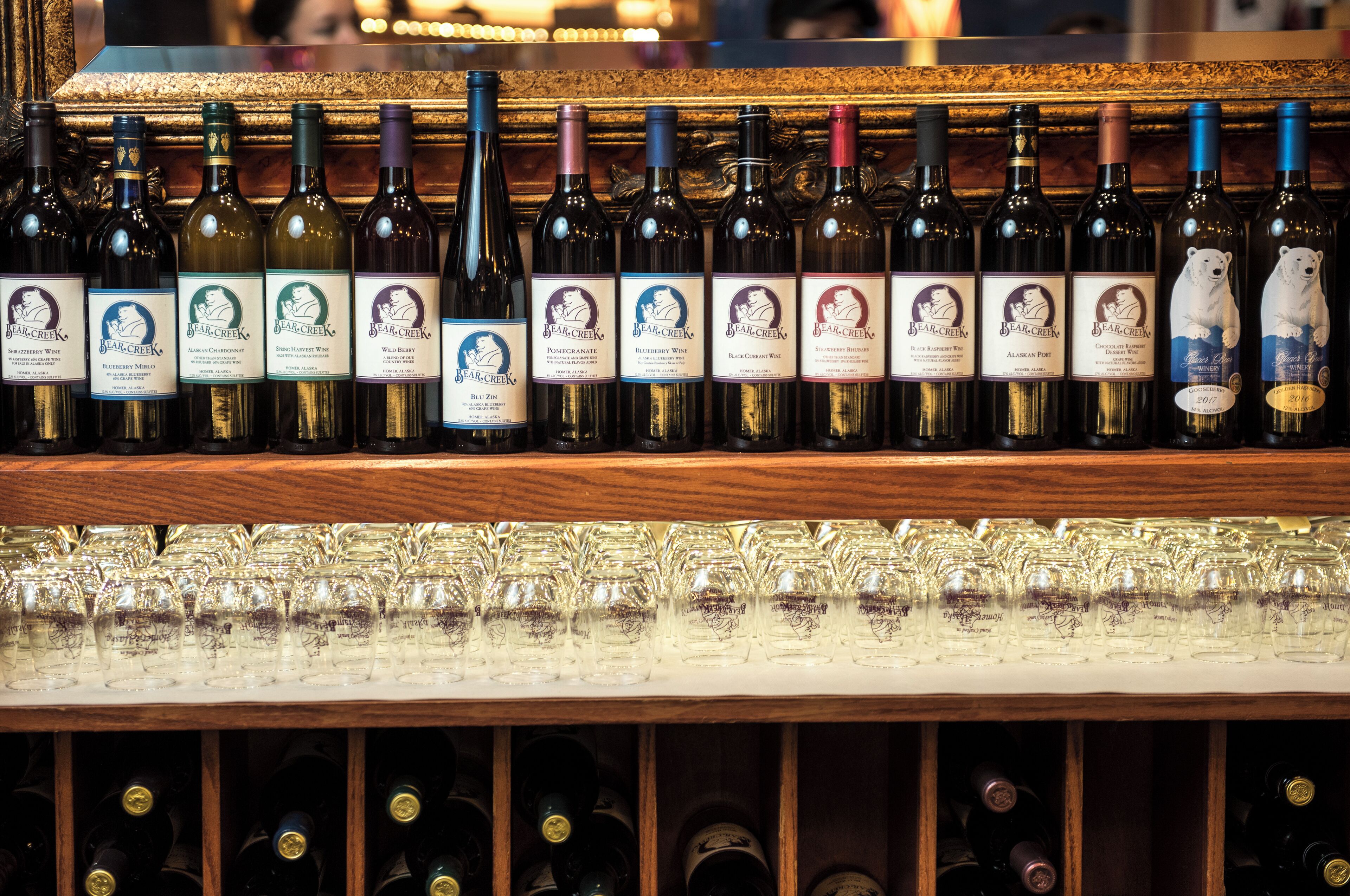 A wine rack with multiple bottles and glasses.