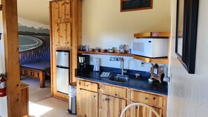 Une cuisine de taille réduite, dotée de meubles en bois, d’un four à micro-ondes encastré et d’un évier.