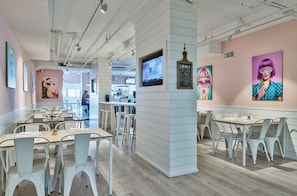A modern interior with white furniture, a bar area, and artwork on the walls.