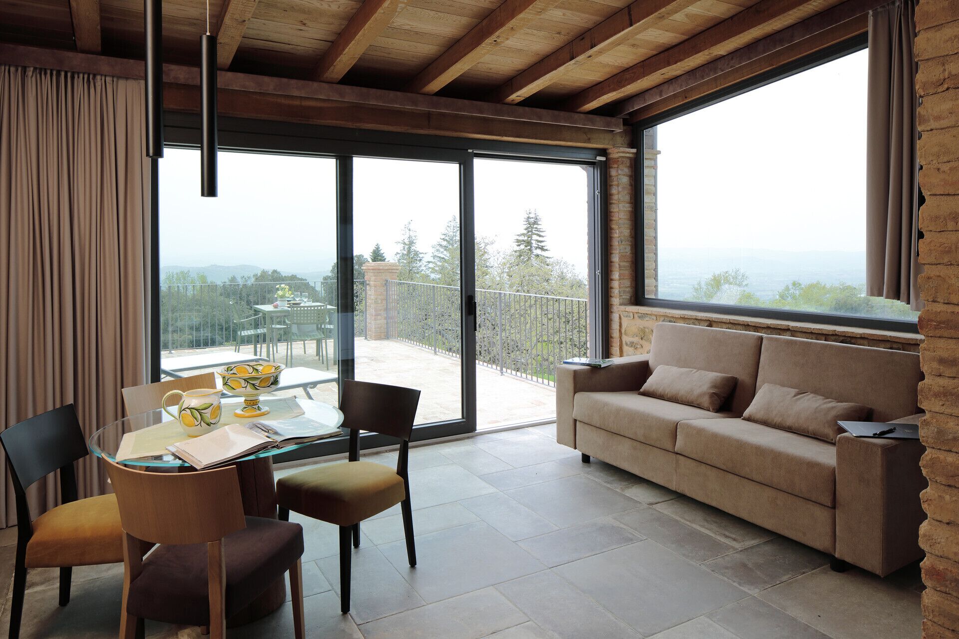 Una sala de estar moderna con sofá, una mesa de comedor con sillas y un balcón con vistas.