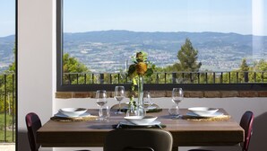A dining table set for four with a view of a distant town and mountains. - Villa Antica Dimora intera struttura - Homelike Villas (San Donato)