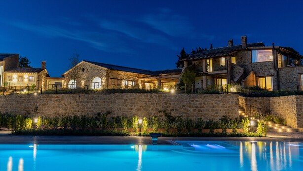 A stone building with multiple windows and a swimming pool in the foreground. - Villa Antica Dimora intera struttura - Homelike Villas (San Donato)