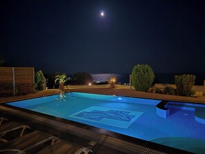 Una piscina al aire libre, sillones reclinables de piscina