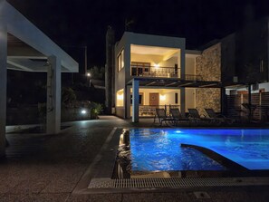 Una piscina al aire libre, sillones reclinables de piscina