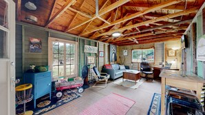 L’intérieur d’un chalet rustique comprend un lit en mezzanine, un bureau, une chaise et un canapé.