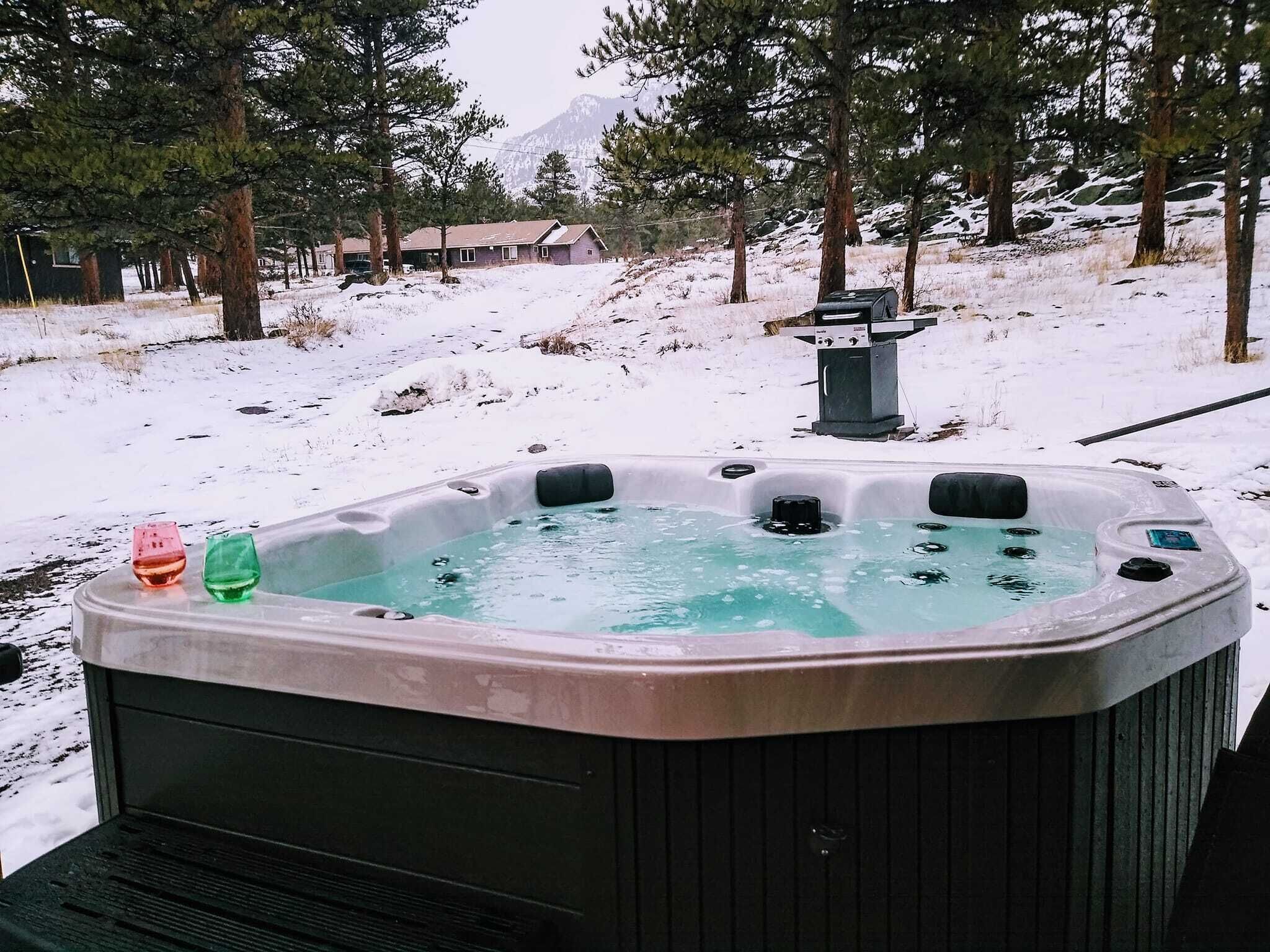 Un jacuzzi en un entorno nevado al aire libre, con una montaña de fondo.