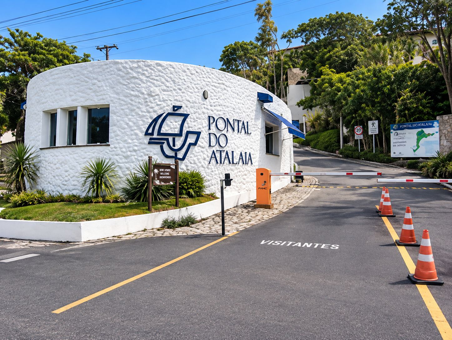 Un edificio bianco con un cartello che riporta la scritta 'PONTAL DO ATALAIA' e un logo blu. Sulla strada di fronte ci sono coni stradali arancioni.
