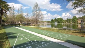 Ein Shuffleboardfeld mit Teich und Bäumen im Hintergrund.