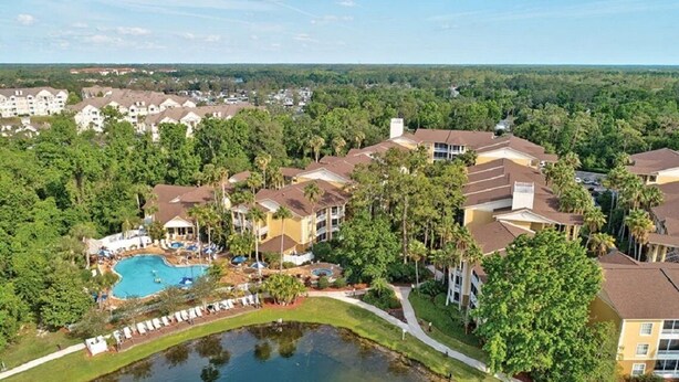 Ein Resort mit mehreren Gebäuden, einem Schwimmbad und einem Teich.