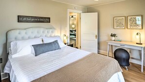 Ein ordentlich eingerichtetes Schlafzimmer mit einem großen Bett, einem Schreibtisch und einem Stuhl.