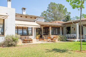 A house with a patio area featuring outdoor furniture, a covered seating area, and a view of the surrounding landscape.