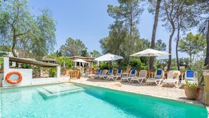 A pool area with lounge chairs and umbrellas, surrounded by trees. - Ca na Tinta - with private swimming pool (Algaida)