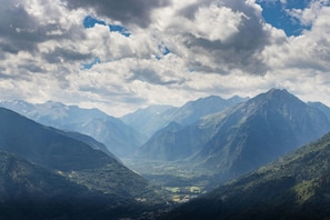 A mountainous landscape with a valley and distant mountains.