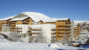 En snötäckt bergsort med trähus och balkonger.