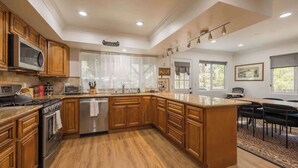 Une cuisine moderne avec des meubles en bois, des appareils en acier inoxydable et un grand îlot central.