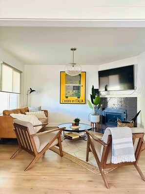 TV connectée, cheminée, livres, chaîne hi-fi