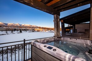 A hot tub with a view of snow-covered mountains. - Brand new 2 bedroom with incredible mountain views, private hot tub , air conditioning! (Whitefish)