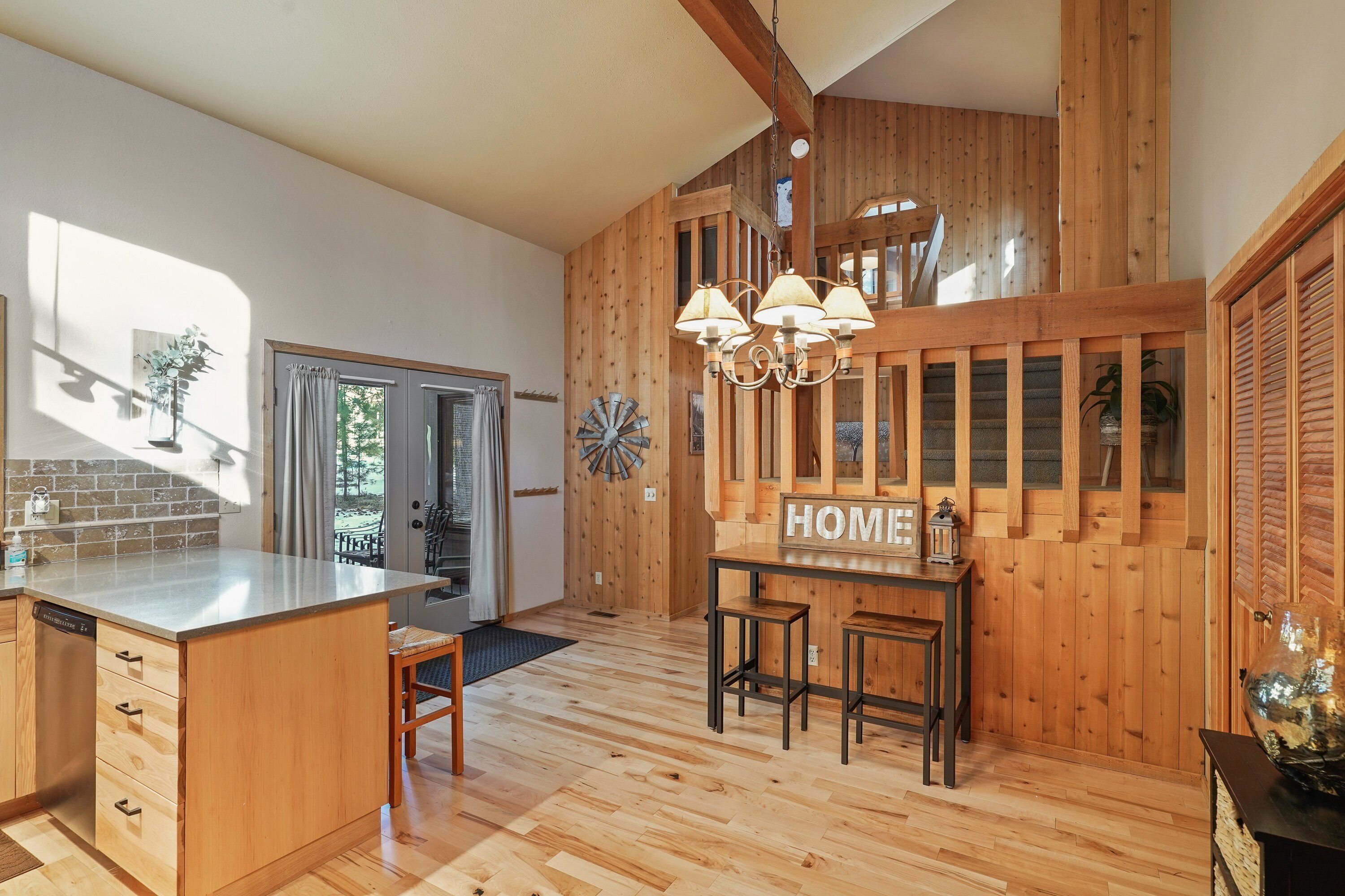 A spacious kitchen with wooden accents, a central island, and a 'HOME' sign on the wall.