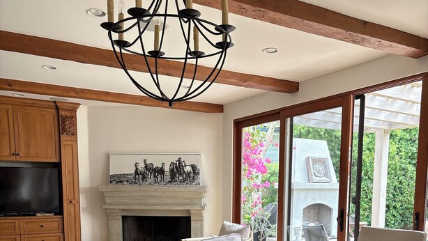 A spacious dining area with a large table, wicker chairs, and a fireplace.