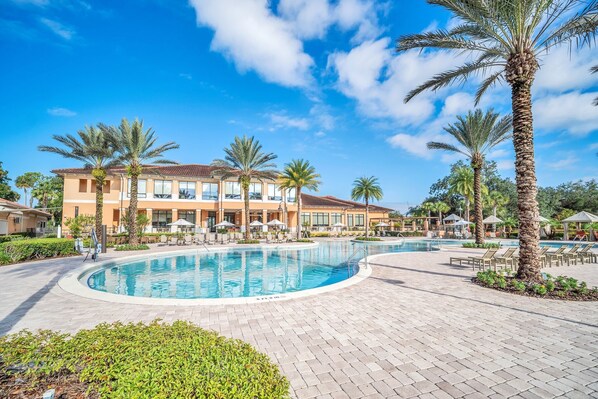 A resort with a large pool, palm trees, and a building with multiple balconies. - Luxury/pool & waterslides/close to Disney (Kissimmee)