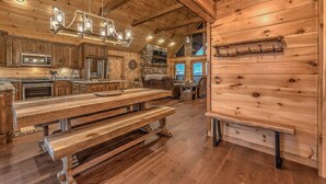 Una cucina rustica con mobili in legno, un camino in pietra e un grande tavolo da pranzo in legno.