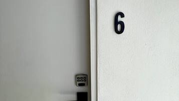 A door with a numeric keypad lock and the number 6 on the door.