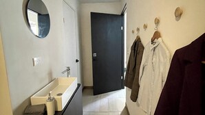 Une salle de bain moderne avec un lavabo, un miroir et un porte-serviettes.
