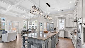A spacious kitchen with a large island, white cabinetry, and modern appliances.