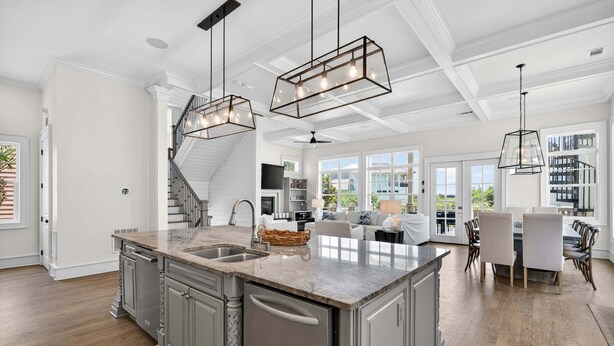 A spacious kitchen with a large island, built-in appliances, and pendant lighting.