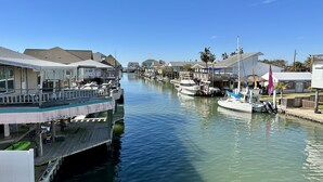 Ein Yachthafen mit vertäuten Booten, Holzstegen und Häusern am Wasser.