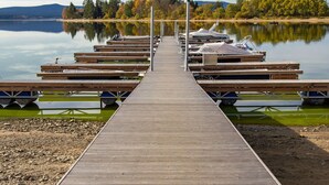 A wooden pier extending into calm water with docked boats and a forested hillside in the background. - Beautiful apartment for 2 guests with WIFI, TV, terrace and pets allowed (Lojzova Paseka)