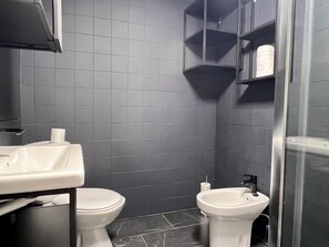 A bathroom with a toilet, bidet, and sink, all in white. - Housing León La Paloma (León)