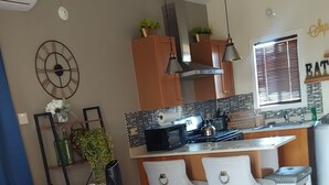 A modern living room with a sofa, coffee table, and a dining area with chairs. - SUPREME LIVING VACATION HOME. Your home away from home!  (Portmore)