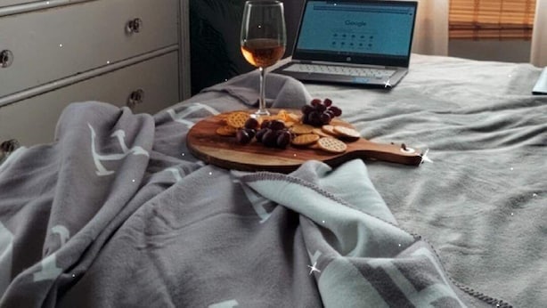 A bedroom with a bed, a laptop on a bedside table, a glass of wine, and a TV on a dresser. - SUPREME LIVING VACATION HOME. Your home away from home!  (Portmore)