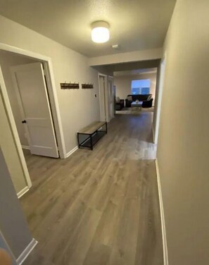 Stylish hallway with a door, bench, and comfortable couch.