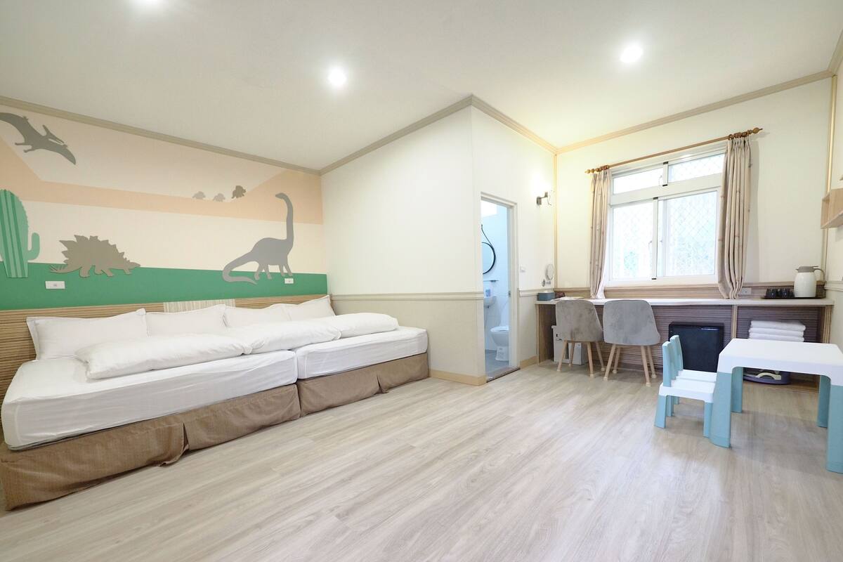 A room with a bed, a desk, and a window.